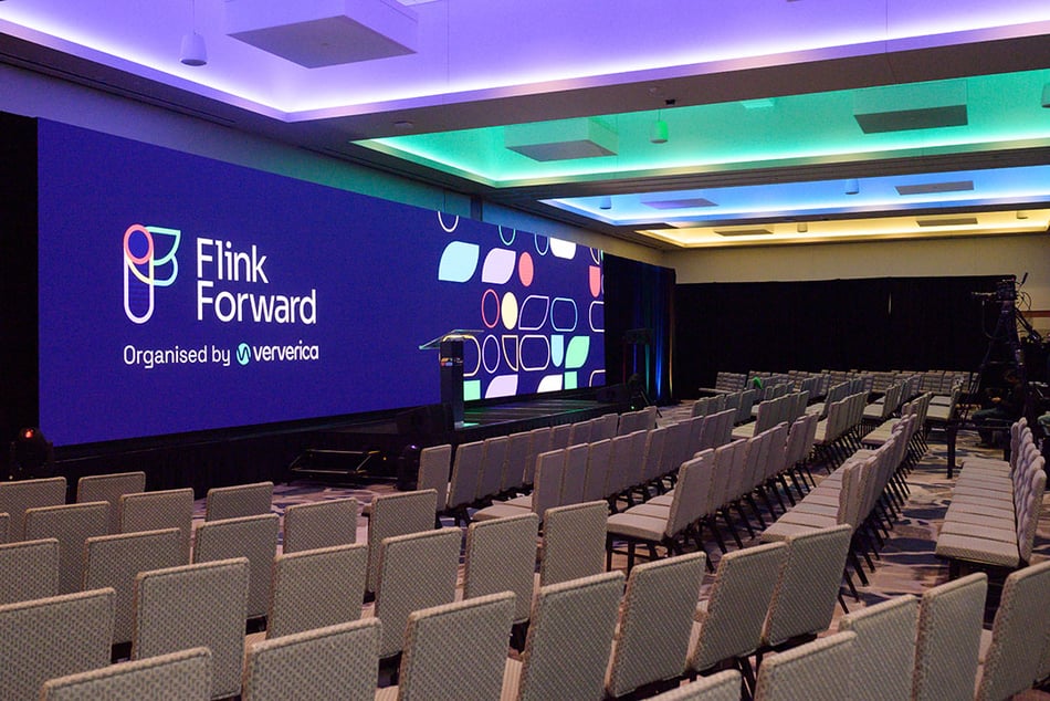 Empty stage with Flink Forward, Organized by Ververica logo on screen.